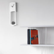 COVO AIKA Vægur – elegant pendulvægur i lakeret stål (18 × 4,2 × H 54 cm), designet af Ari Kanerva, til moderne boligindretning